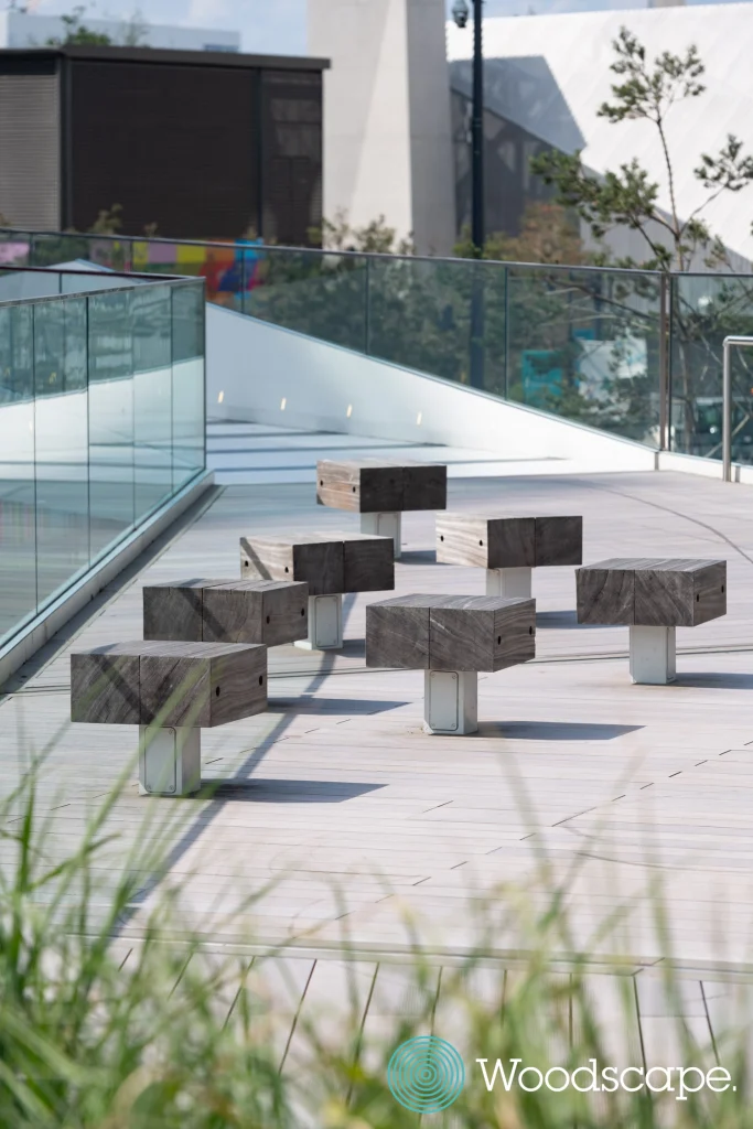 lovely square wooden mushroom style seating atop The Tide bridge in Greenwich Peninsula, London. Crafted by Woodscape